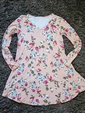 Soft peach pink swing dress with an allover floral print. Long sleeves and a V-n